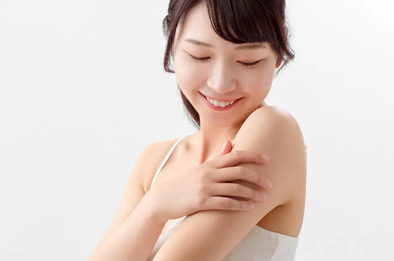 自分の肌に触れる女性